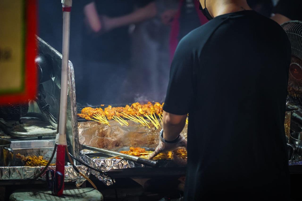 Grilling satay skewers at night market